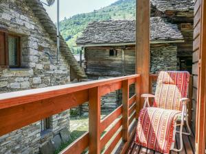 two chairs on a porch of a log cabin at Chalet Rustico Casa Fortuna by Interhome in Madra