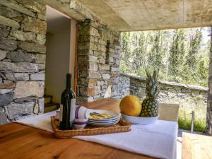 a table with a bottle of wine and a bowl of fruit at Chalet Rustico Casa Fortuna by Interhome in Madra
