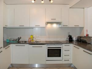 a kitchen with white cabinets and a stove top oven at Apartment Coris by Interhome in Vira