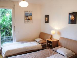 ヴィラにあるApartment Coris by Interhomeのベッド2台、ソファ、窓が備わる客室です。