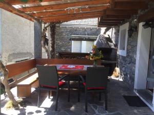 een patio met een tafel en stoelen en een piano bij Holiday Home Casa Anna by Interhome in Agarone