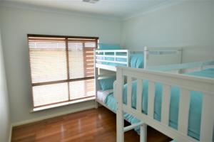 a bedroom with two bunk beds and a window at Stan Breeze: Elegant Family Retreat in Stansbury
