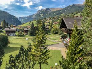 un pueblo en las montañas con una casa y árboles en Apartment Chalet Spassvogel by Interhome, en Grindelwald
