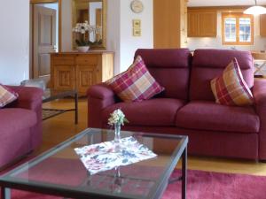 sala de estar con sofás morados y mesa de cristal en Apartment Chalet Nagano by Interhome, en Grindelwald