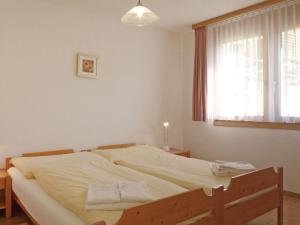 a bedroom with a large bed with a window at Apartment Rose Apt- Y by Interhome in Wengen