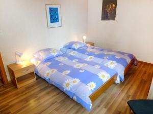 Un dormitorio con una cama con un edredón azul. en Apartment San Giorgio A 12 by Interhome, en Crans-Montana