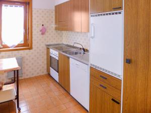 cocina con nevera blanca y fregadero en Apartment San Giorgio A-B by Interhome, en Crans-Montana