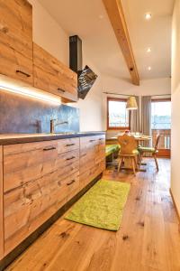 Verano的住宿－Untermathonhof Abendrot，厨房配有木制橱柜和绿色地毯。