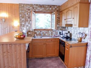una cucina con armadi in legno, lavandino e finestra di Apartment Sapin Bleu 5 by Interhome a Villars-sur-Ollon Altre 14 foto