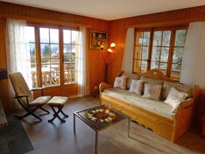 ein Wohnzimmer mit einem Sofa und einem Tisch in der Unterkunft Apartment Sapin Bleu 5 by Interhome in Villars-sur-Ollon