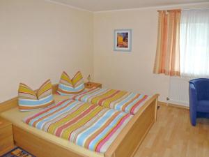 1 dormitorio con 1 cama con almohadas de rayas coloridas en Apartment Fritz by Interhome en Zachenberg
