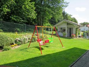 un parque infantil con un columpio en un patio en Apartment Fritz by Interhome en Zachenberg