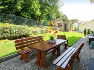 una mesa de picnic y un banco con un parque infantil en el patio trasero en Apartment Fritz by Interhome en Zachenberg