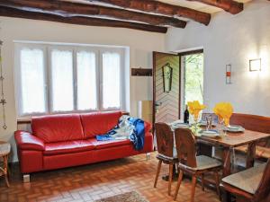 a living room with a red couch and a table at Holiday Home Casa la Rustica by Interhome in Brione