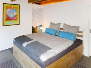 a bedroom with a wooden bed with blue pillows at Chalet Christine by Interhome in Molberting