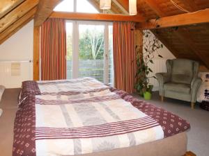 a bedroom with a bed and a chair and a window at Chalet Christine by Interhome in Molberting +16 photos