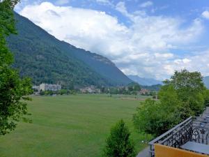 a large green field with mountains in the background at Apartment Modern by Interhome in Interlaken
