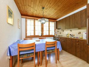 uma cozinha com uma mesa azul com cadeiras e um lavatório em Apartment Chalet Marie Rosa-1 by Interhome em Grindelwald