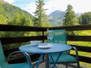 een blauwe tafel en stoelen op een balkon met een glas bij Apartment Mont Fort 55 by Interhome in Siviez