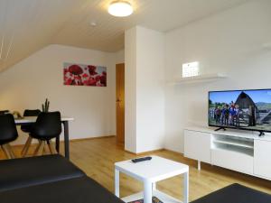 a living room with a tv and a table at Apartment Land in Sicht by Interhome in Rulfingen