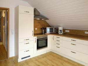 a kitchen with white cabinets and a microwave at Apartment Land in Sicht by Interhome in Rulfingen