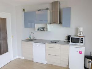 a kitchen with white cabinets and a microwave at Apartment Isabelle-1 by Interhome in Cabourg