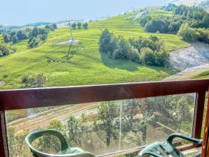 a view of a green field from a window at Studio Lunik Orion-12 by Interhome in Le Corbier