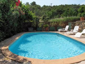 a large swimming pool with two chairs and a table at Holiday Home Oleander by Interhome in Tordères