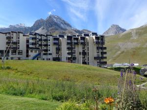a building on a hill with mountains in the background at Apartment Le Prariond-4 in Tignes