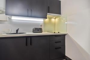a kitchen with black cabinets and a sink at Vall d'Incles TOP NATURE, A13, HUT 5836 in Canillo +14 photos