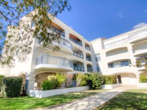 um grande edifício branco com arbustos à frente em Apartment Parc de Pontaillac-3 by Interhome em Pontaillac