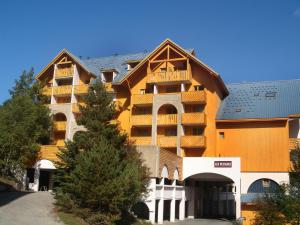 un grand immeuble d'appartements avec un toit en gambrel dans l'établissement Apartment Chalets du Soleil-21 by Interhome, à Les Deux Alpes