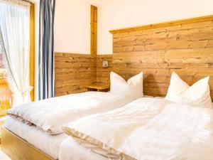 ライト・イム・ヴィンクルにあるApartment Unterberg by Interhomeのベッドルーム(白い大型ベッド1台、木製ヘッドボード付)