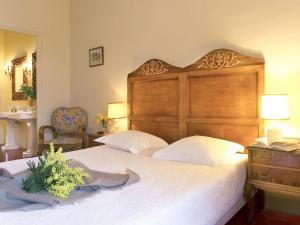 Le RacouにあるHoliday Home Villa Jaume by Interhomeの木製のヘッドボードが付いた大きなベッドのある寝室