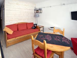 a living room with a couch and a table at Apartment Plagne Centre 3 - LAP173 by Interhome in La Plagne