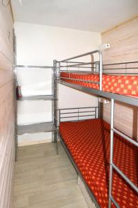 a room with two bunk beds with red sheets at Apartment Plagne Centre 3 - LAP173 by Interhome in La Plagne