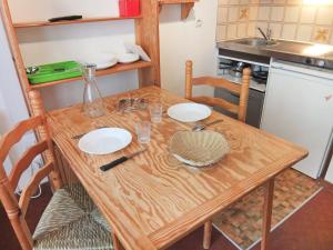 una mesa de madera con dos platos en la cocina en Apartment L'Astragale-1 by Interhome en Les Menuires