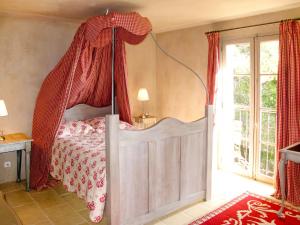 ロルグにあるHoliday Home Le Collet des Redons - LOG170 by Interhomeのベッドルーム1室(赤いカーテン付きの天蓋付きベッド1台付)