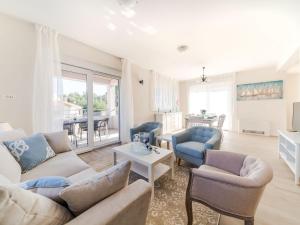 ein Wohnzimmer mit einem Sofa, Stühlen und einem Tisch in der Unterkunft Holiday Home Lucija - ZAD730 by Interhome in Pridraga