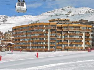 ヴァル・トランスにあるApartment Le Roc de Peclet by Interhomeの雪中の大きな建物(スキーリフト付)