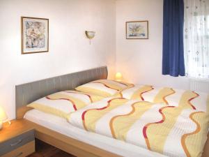 1 dormitorio con 1 cama con edredón a rayas en Holiday Home Paula by Interhome, en Bayerisch Eisenstein