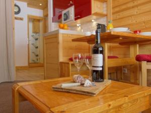 a bottle of wine and a glass on a table at Apartment Le Pramecou-5 by Interhome in Tignes