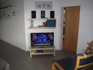 ein Wohnzimmer mit einem TV und einem Tisch mit einem TV in der Unterkunft Apartment Strandvilla - LUB111 by Interhome in Lubmin