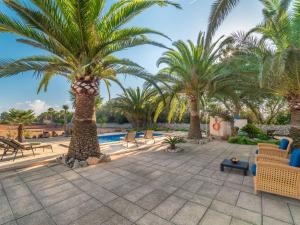 a courtyard with palm trees and a pool at Holiday Home Morla by Interhome in Porreres