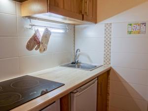 een kleine keuken met een wastafel en een fornuis bij Apartment Les Moutières B1 et B2 - Val Claret-18 by Interhome in Tignes