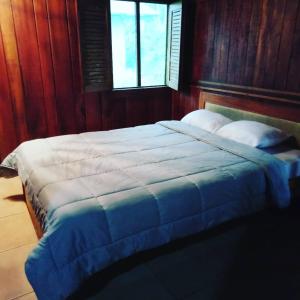 Schlafzimmer mit einem großen Bett und Holzwänden in der Unterkunft Pochotel in Turrialba