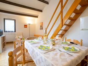 a dining room with a table with plates of food at Holiday Home Les Maisons de la Plage-8 by Interhome in Le Grau-du-Roi