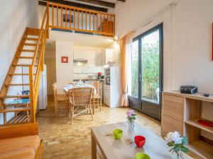 a living room with a table and a kitchen at Holiday Home Les Maisons de la Plage-8 by Interhome in Le Grau-du-Roi