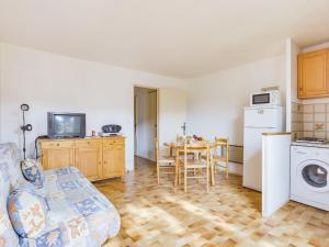 een woonkamer met een bank en een keuken met een tafel bij Apartment Le Centaure by Interhome in Cap d'Agde