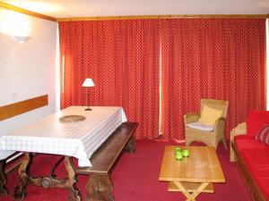 a red room with a bed and a couch at Apartment Plagne Centre 1 - LAP170 by Interhome in La Plagne